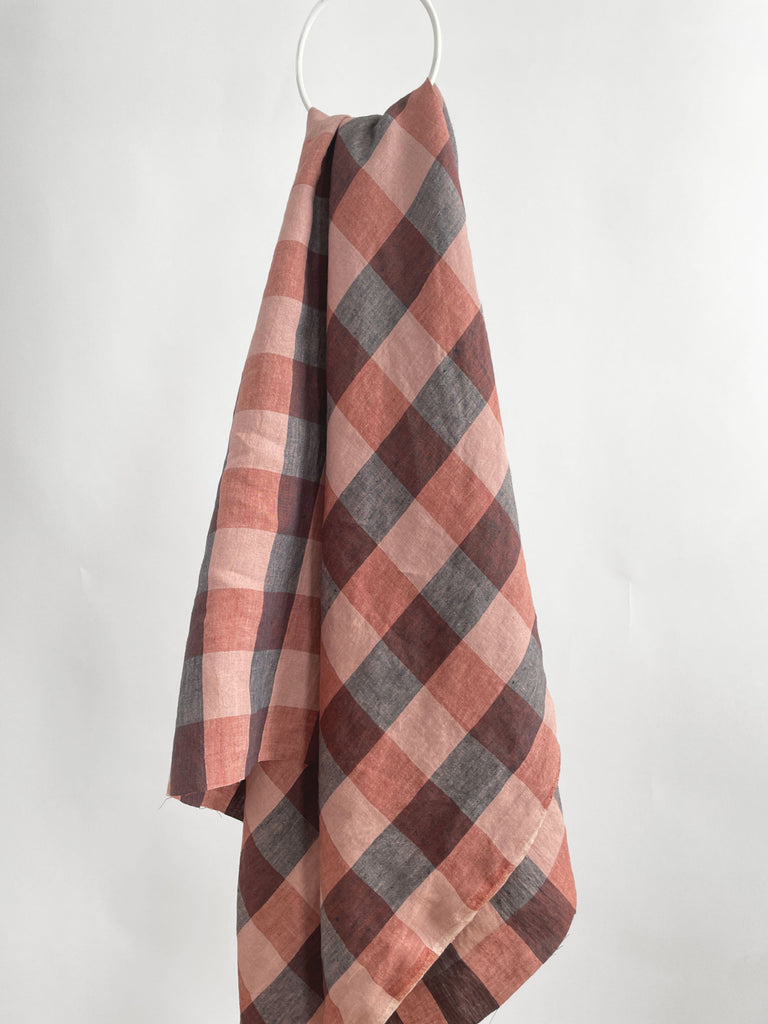a red and black checkered towel hanging on a hook