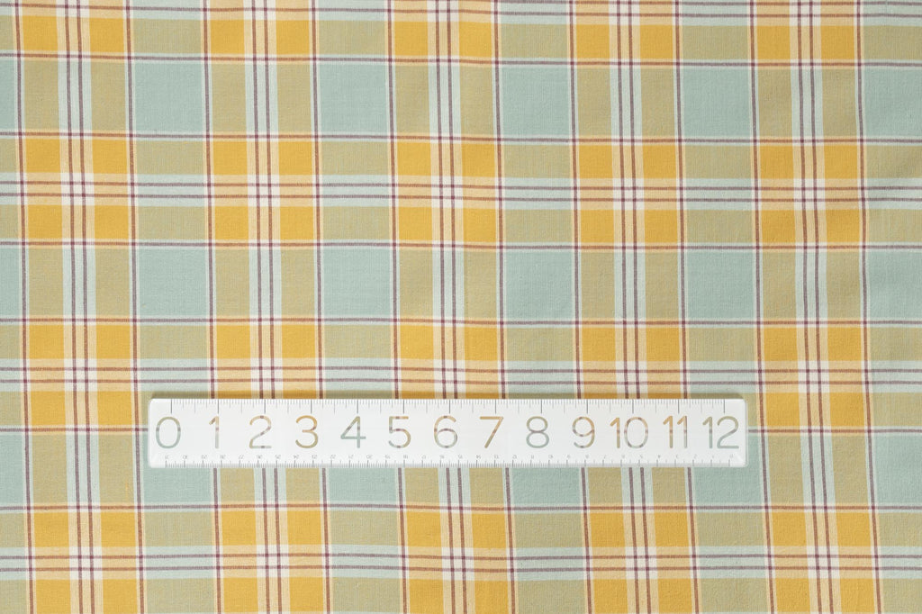 a yellow and blue plaid fabric with a ruler on it