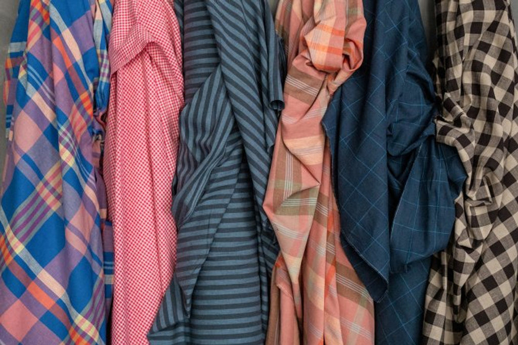 a bunch of shirts are hanging on a rack