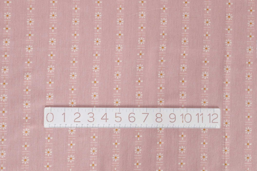 a ruler is on top of a pink fabric