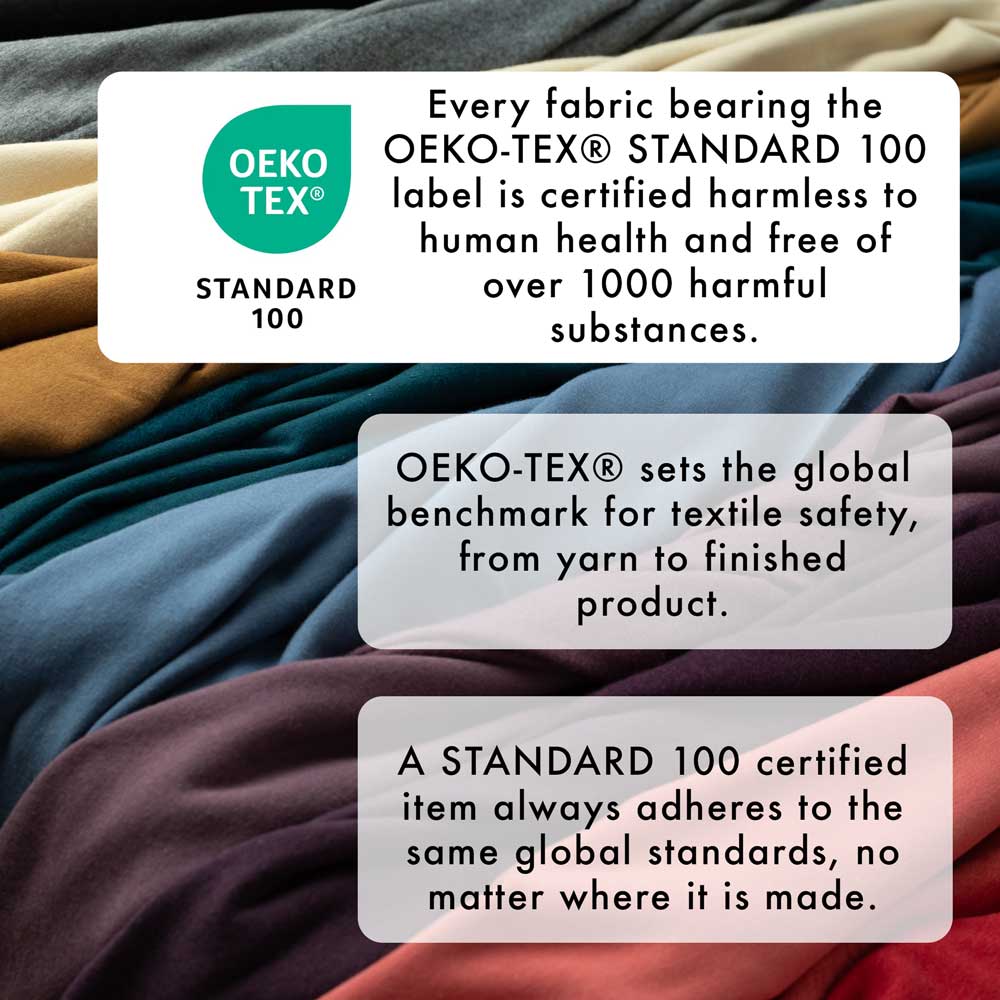 a pile of different colored sheets on a bed