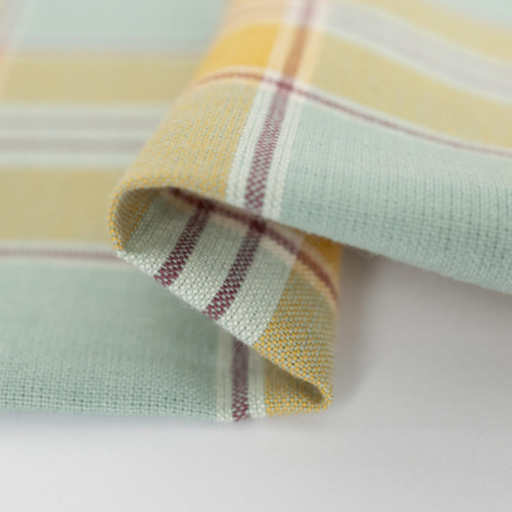 a close up of a plaid fabric on a white surface