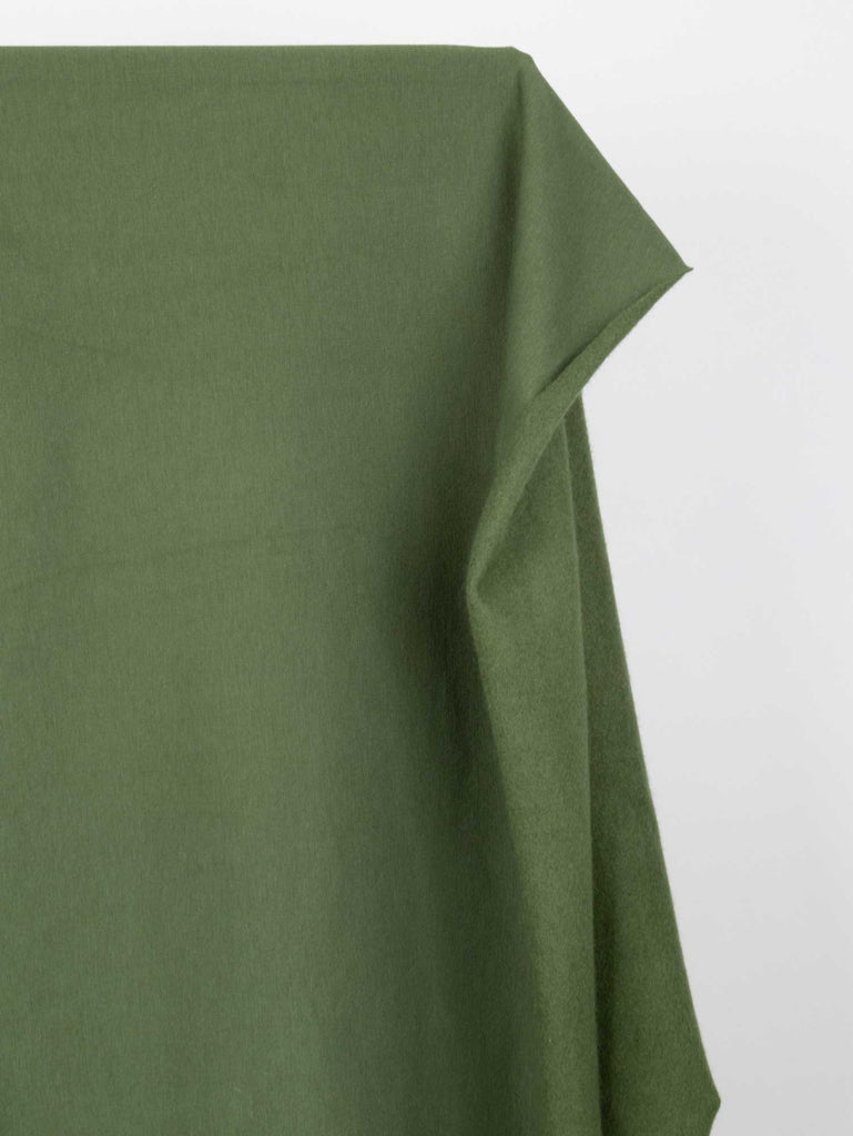 a close up of a green sheet on a bed