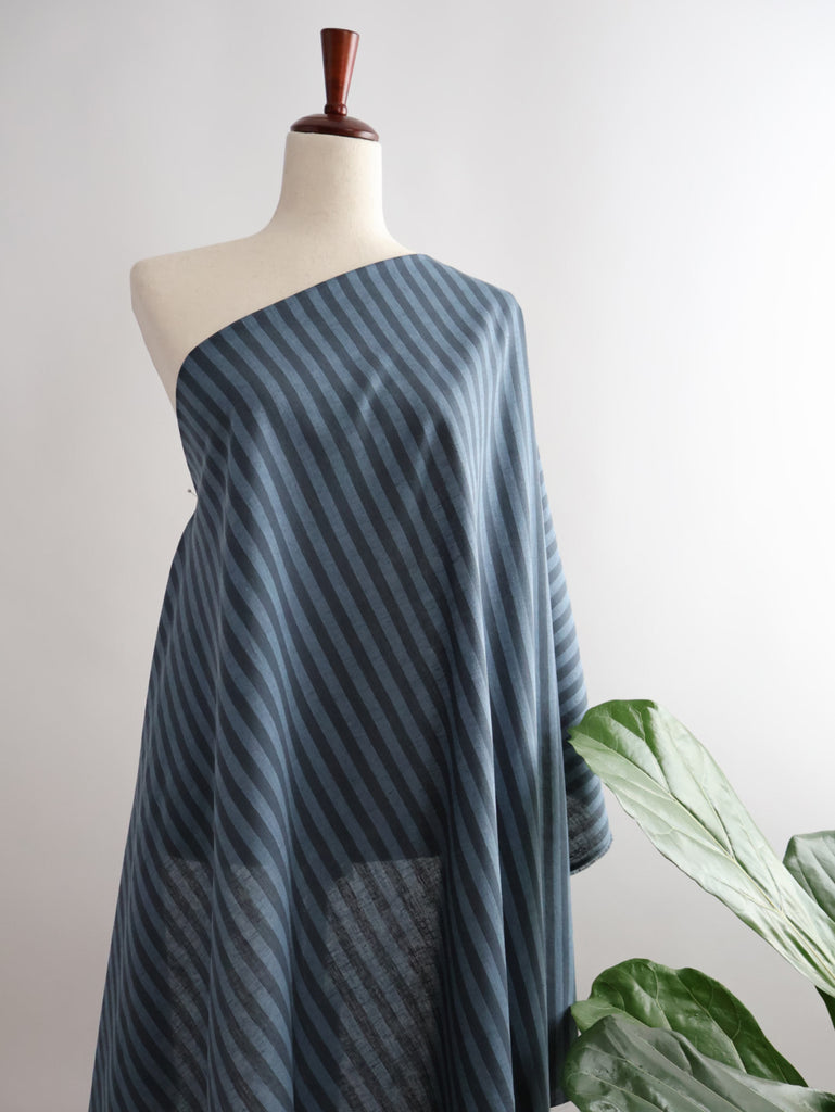 a dress on a mannequin next to a plant