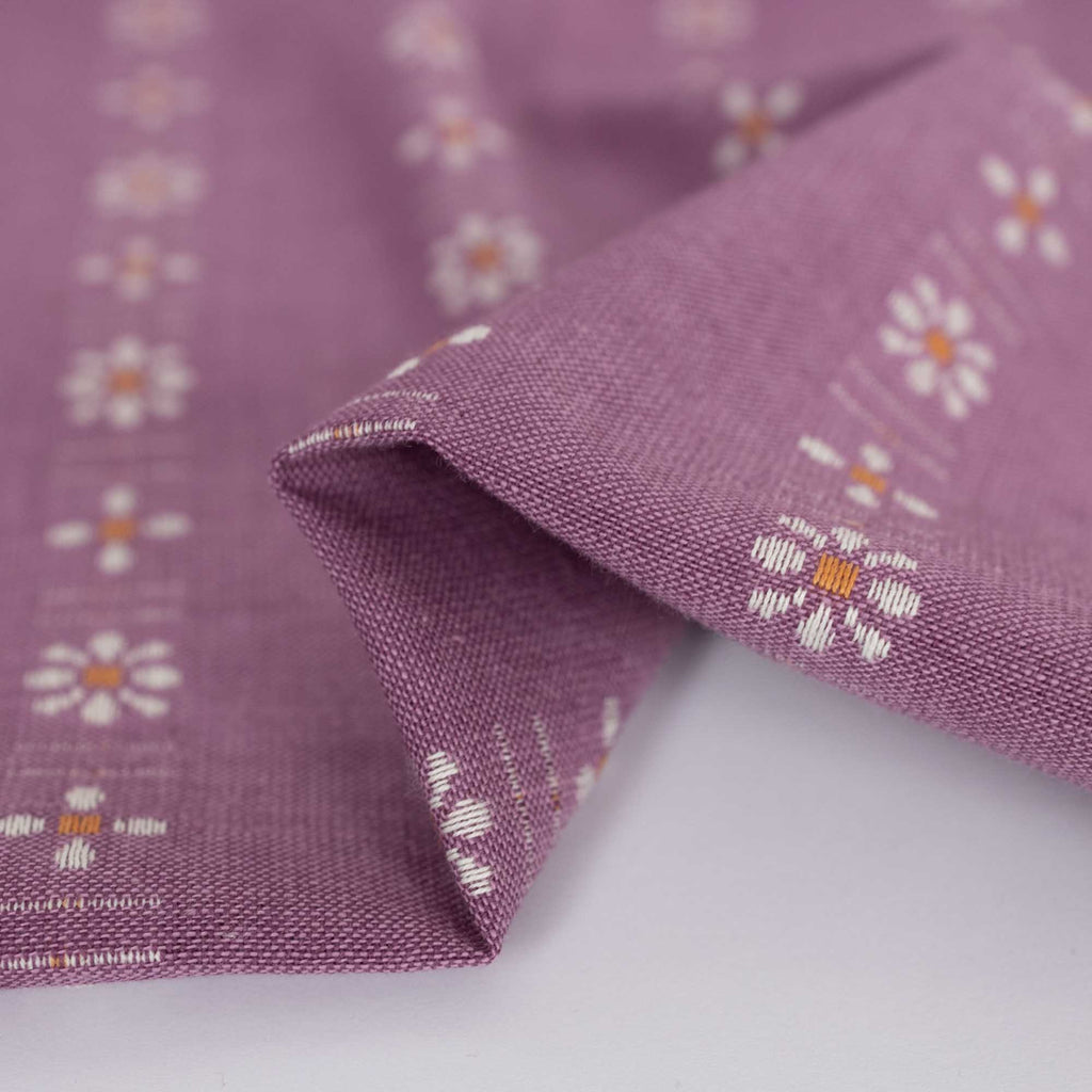 a close up of a purple fabric with flowers on it