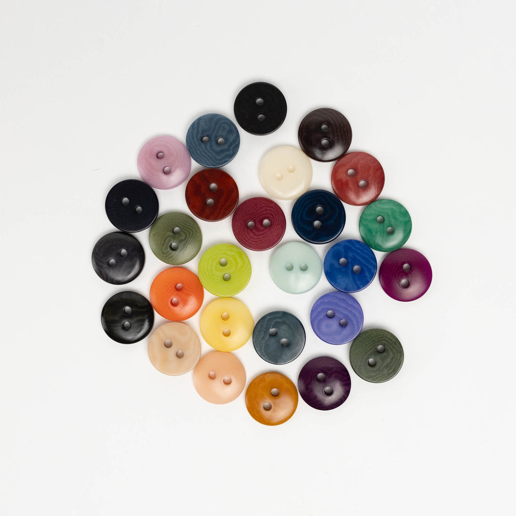 A collection of colorful buttons arranged in a circular pattern against a white background.