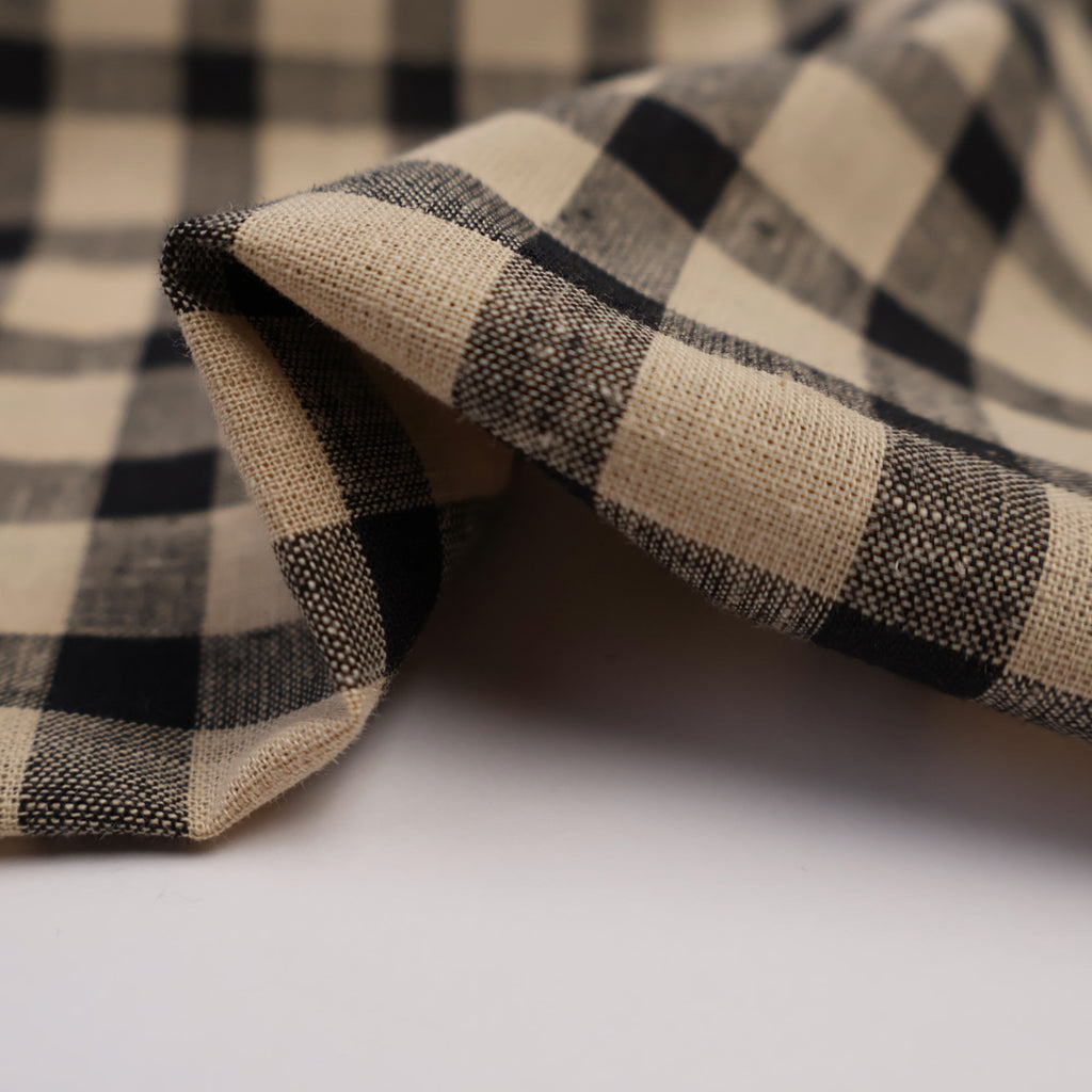 a black and white checkered tie laying on a white surface