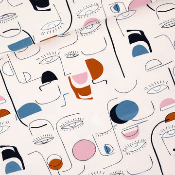 Closeup of Villagers print french terry with abstract faces and shapes.