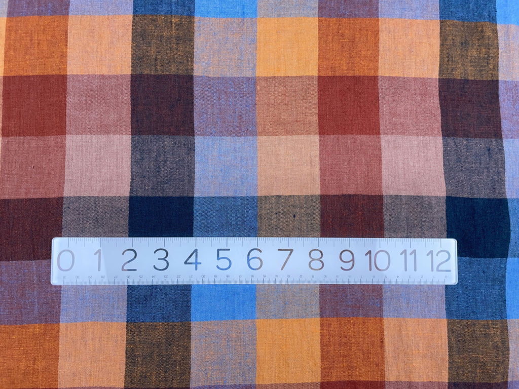 a close up of a plaid fabric with a ruler